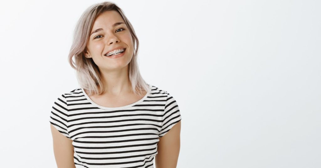 A young woman wearing braces and smiling.