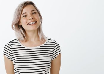 A young woman wearing braces and smiling.