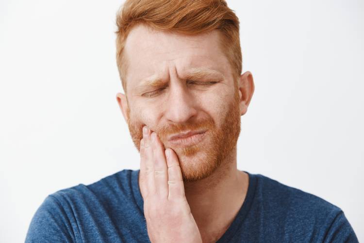 Man is in pain and looking for ways to reduce swelling from tooth infection