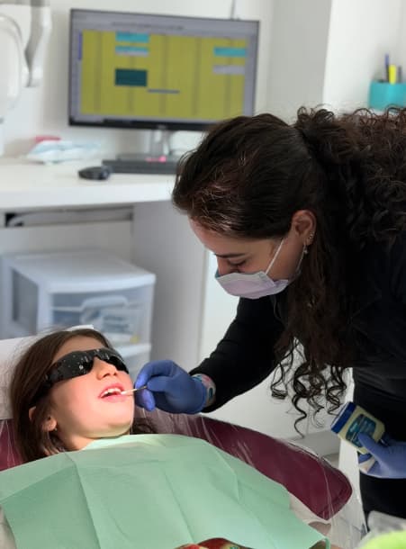 Dentist examining child in clinic